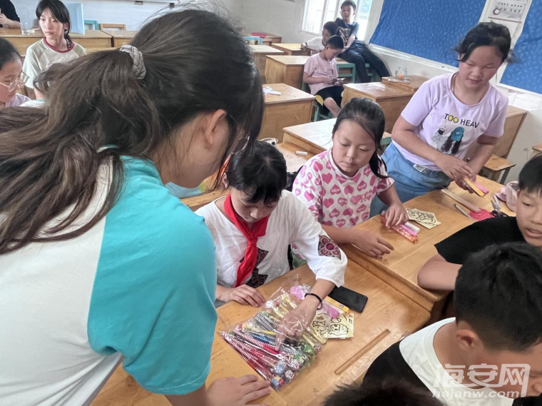 图为老师在给孩子们分发礼品。